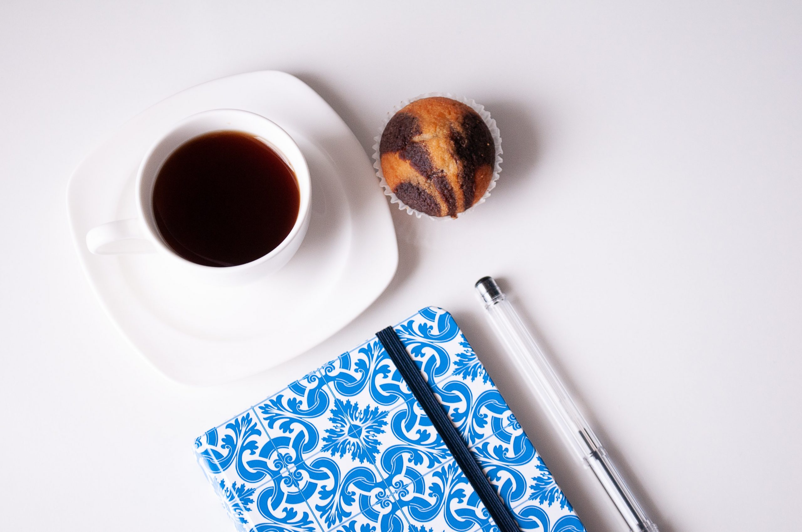 black tea with muffin and journal